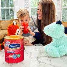 Woman and child with a can of Enfagrow Premium Toddler Nutritional Drink on a marble surface.