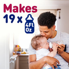 [42732562514101]Man holding a baby and feeding them from a bottle with text indicating bottle capacity.