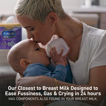 Woman feeding a baby with a bottle, Enfamil packaging in the background