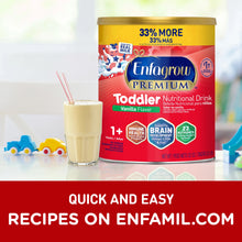 Enfagrow Premium Toddler Nutritional Drink can with a glass of shake on a table with toys in the background.