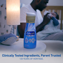 Enfamil Optimum bottle on a table with a blurred background of a person and child, featuring text about product trustworthiness.